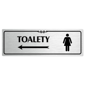 Toalety vlevo ženy, 200x66mm, stříbrná popiska s ozdobou uprostřed